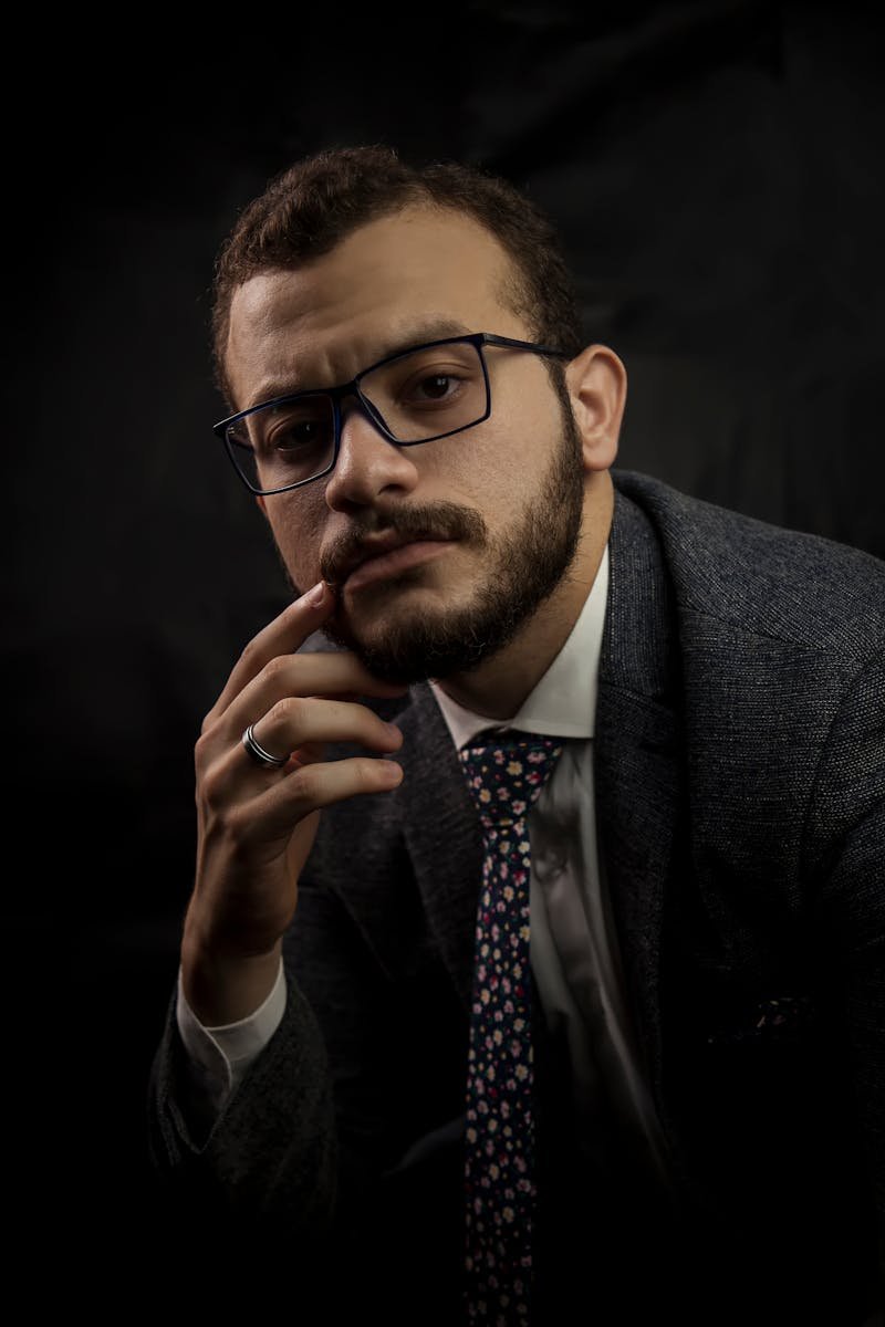 Professional corporate portrait of a bearded man in suit and eyeglasses.